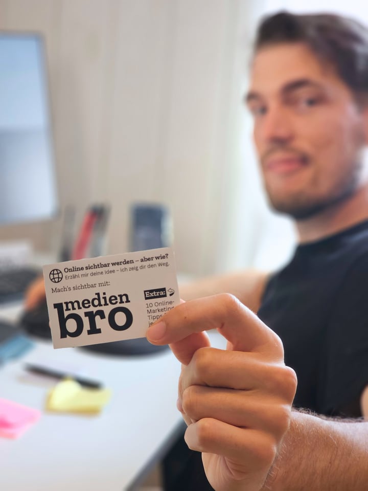 Christoffer Totz zeigt eine Medienbro-Karte mit dem Hinweis Online sichtbar werden